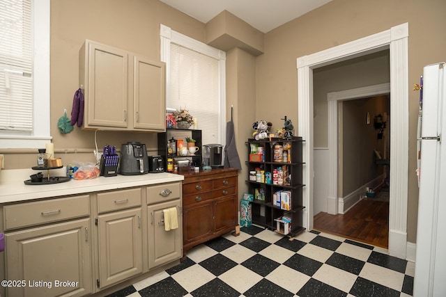 kitchen with freestanding refrigerator, light countertops, and light floors