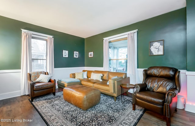living area featuring a wainscoted wall and wood finished floors