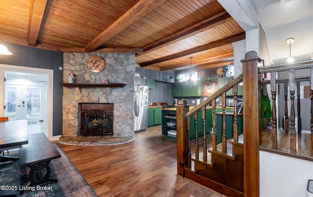 living room with beam ceiling, stairs, wood finished floors, and wood ceiling