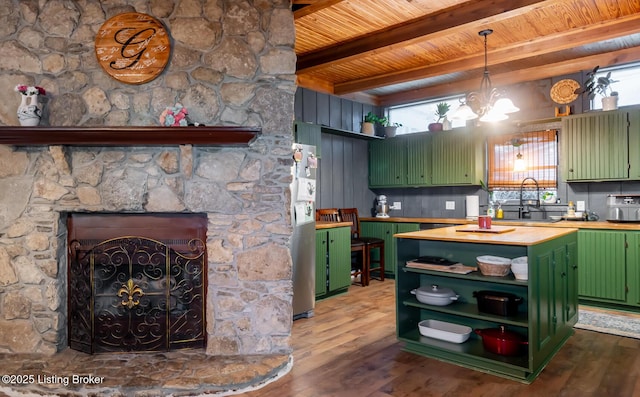 kitchen with wooden ceiling, open shelves, green cabinetry, a sink, and wood finished floors
