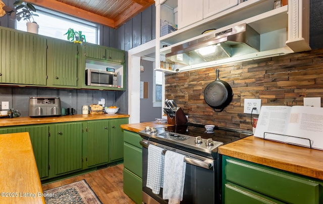 kitchen with stainless steel appliances, under cabinet range hood, wood counters, and decorative backsplash