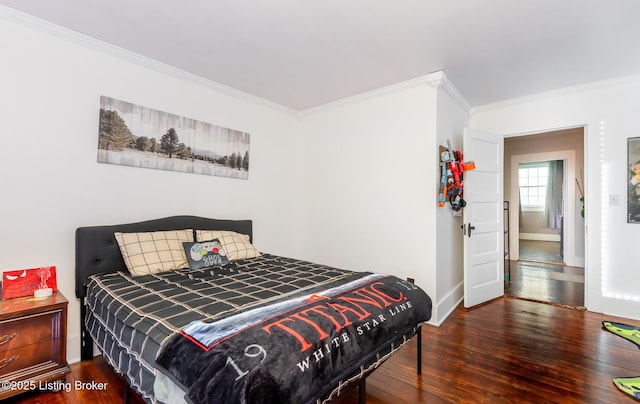 bedroom with baseboards, ornamental molding, and wood finished floors