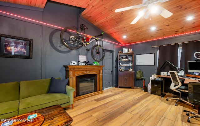 office space featuring ceiling fan, hardwood / wood-style flooring, wood ceiling, a glass covered fireplace, and lofted ceiling