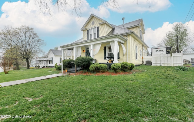 bungalow-style home featuring central AC unit, a front lawn, fence, and covered porch