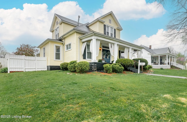 view of front of home featuring a front yard, fence, and covered porch