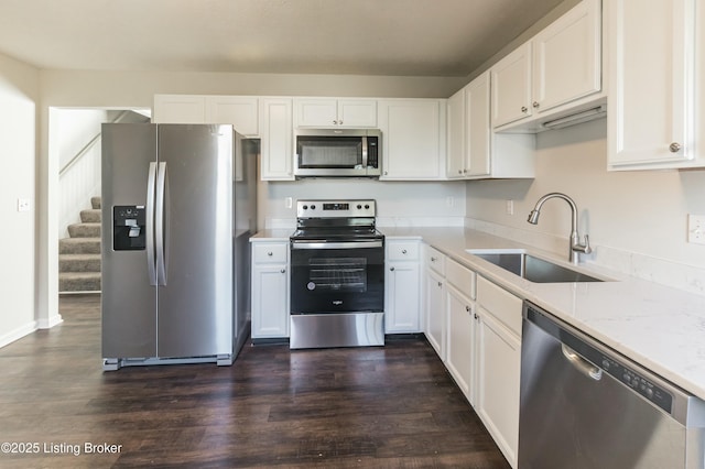 kitchen with dark wood finished floors, white cabinetry, a sink, and appliances with stainless steel finishes