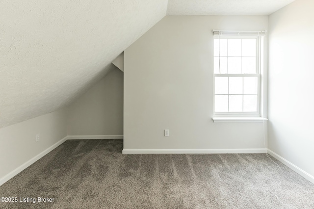 bonus room featuring baseboards, a textured ceiling, and plenty of natural light
