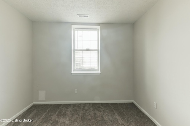 empty room with baseboards, a textured ceiling, visible vents, and dark colored carpet