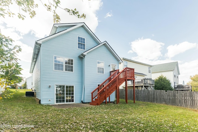 rear view of house with a lawn, stairs, fence, and a wooden deck