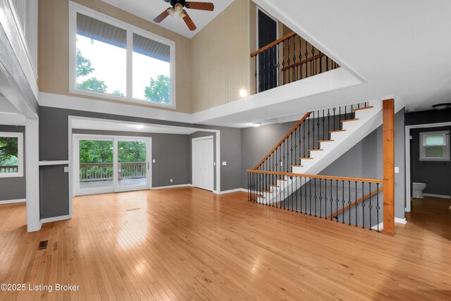 1468 Lakeshore Pkwy, Brandenburg, KY 40108 - unfurnished living room with a towering ceiling, hardwood / wood-style flooring, ceiling fan, and stairway