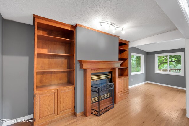 1468 Lakeshore Pkwy, Brandenburg, KY 40108 - unfurnished living room featuring a textured ceiling, light wood-type flooring, a fireplace, and lofted ceiling