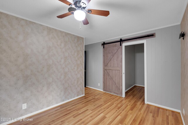 1468 Lakeshore Pkwy, Brandenburg, KY 40108 - unfurnished bedroom featuring a barn door, wood finished floors, crown molding, and ceiling fan