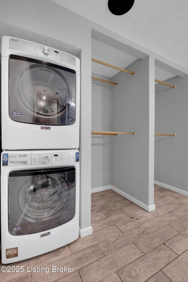 1468 Lakeshore Pkwy, Brandenburg, KY 40108 - laundry room with stacked washer and clothes dryer, wood finished floors, and a textured ceiling