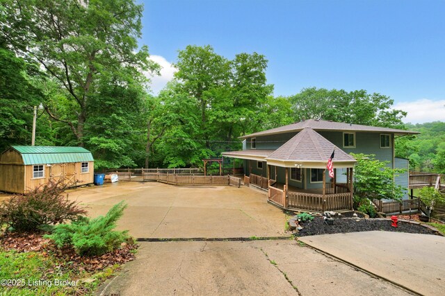 1468 Lakeshore Pkwy, Brandenburg, KY 40108 - view of front facade with a porch, driveway, a storage shed, and roof with shingles