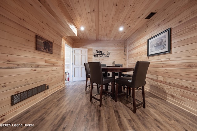 dining space with wood finished floors, wood ceiling, wood walls, and visible vents