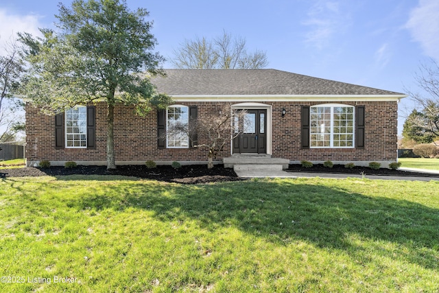 ranch-style home featuring brick siding, roof with shingles, and a front lawn