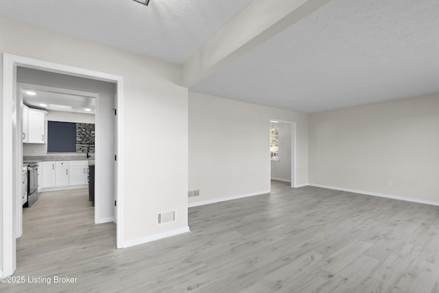 interior space featuring baseboards, light wood-style floors, and visible vents