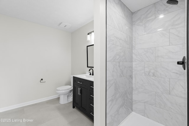 bathroom with baseboards, vanity, toilet, and tiled shower