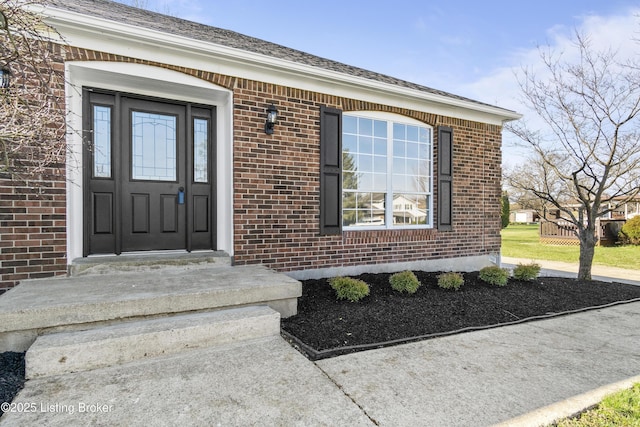 view of exterior entry featuring brick siding