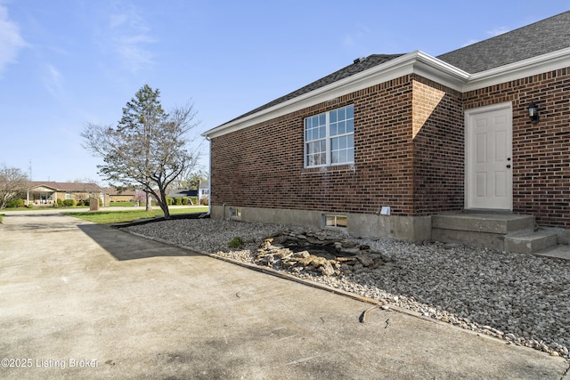 view of side of property with brick siding and concrete driveway