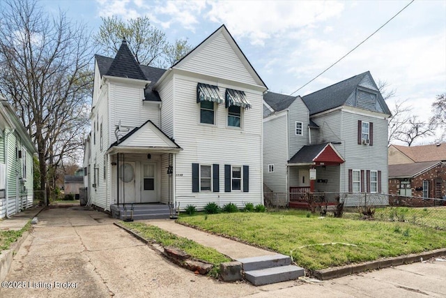 victorian-style house with a front yard and fence