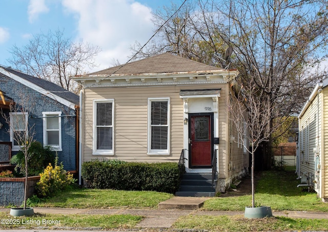 shotgun-style home featuring fence, a front lawn, and entry steps