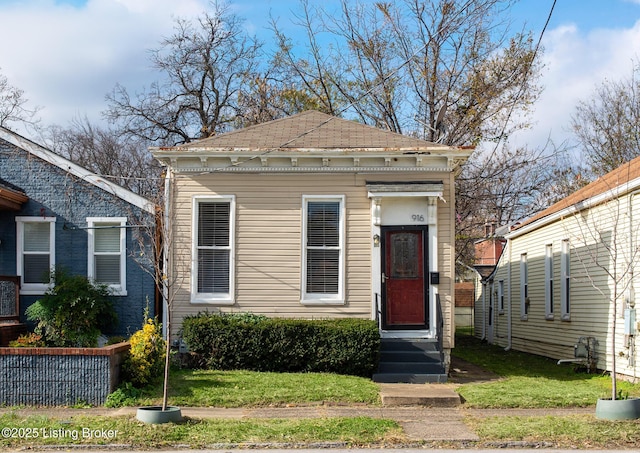 view of front of home featuring a front yard, a shingled roof, and entry steps