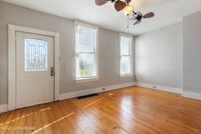entrance foyer with a ceiling fan, baseboards, light wood finished floors, and visible vents