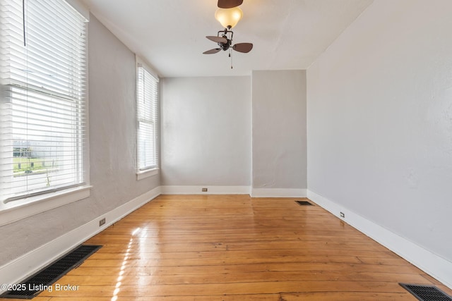unfurnished room featuring baseboards, visible vents, light wood-style floors, and ceiling fan