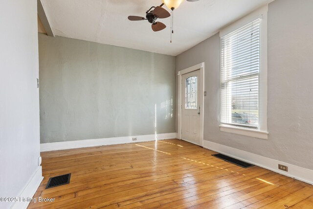 entryway with baseboards, light wood-style floors, ceiling fan, and visible vents