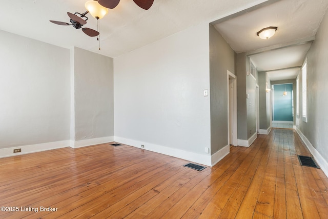 unfurnished room featuring visible vents, light wood-style floors, and a ceiling fan