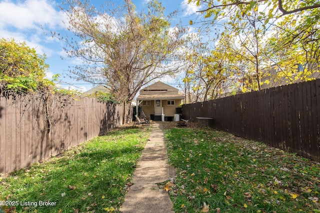 view of yard with a fenced backyard and an outbuilding