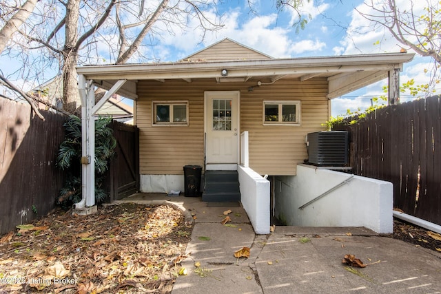 back of house featuring central air condition unit, entry steps, and fence
