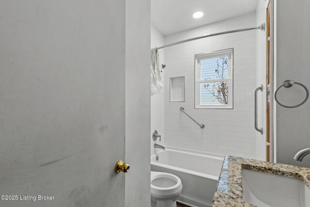 bathroom featuring toilet, a sink, and shower / bathtub combination with curtain