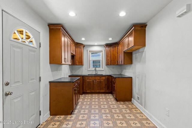 kitchen featuring brown cabinets, dark countertops, recessed lighting, and light floors