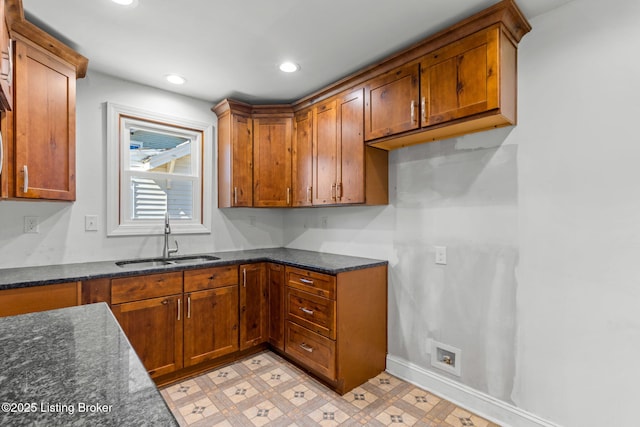 kitchen with a sink, brown cabinetry, and light floors