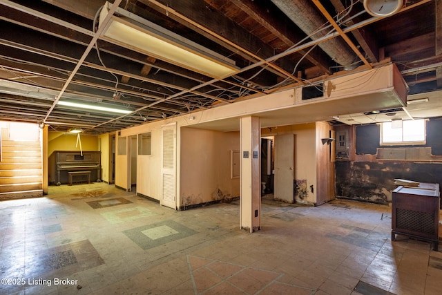 basement with tile patterned floors and stairway