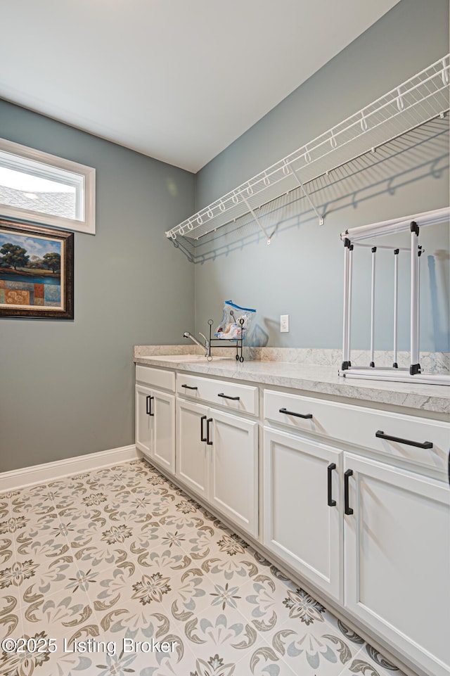 laundry area featuring a sink and baseboards