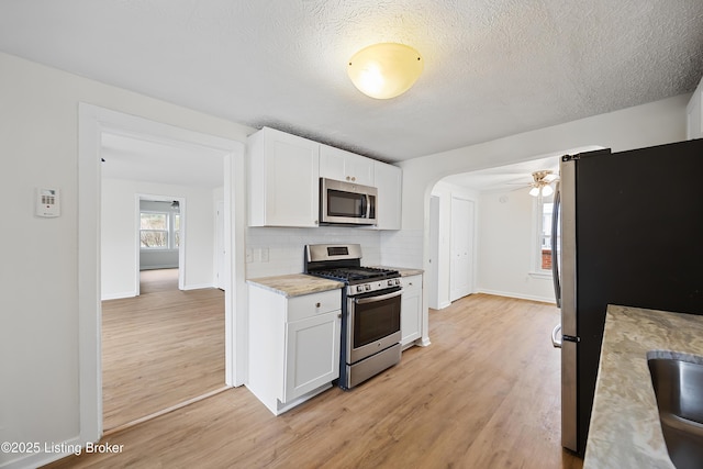 kitchen with white cabinets, light wood-style flooring, and appliances with stainless steel finishes