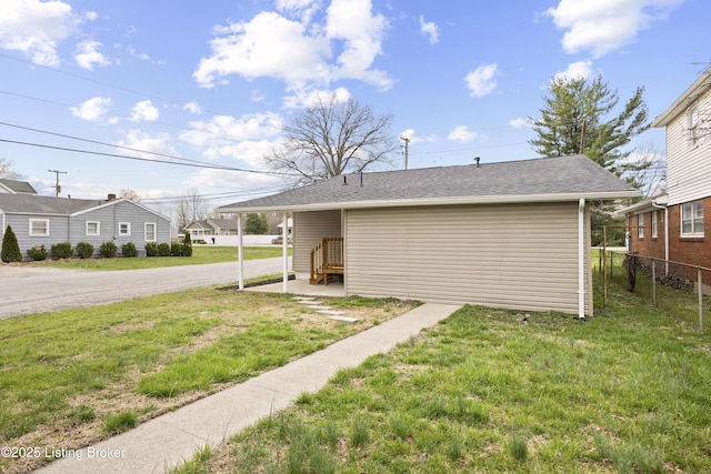exterior space featuring a lawn, fence, and driveway