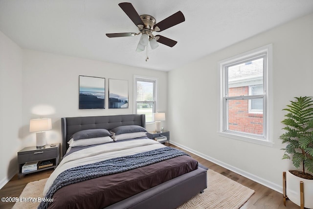bedroom featuring wood finished floors, baseboards, and a ceiling fan