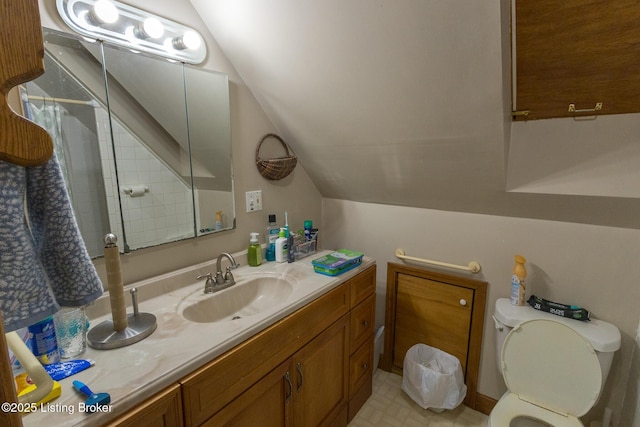 bathroom featuring lofted ceiling, toilet, and vanity