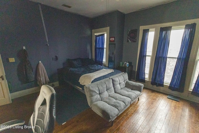 bedroom with hardwood / wood-style floors, baseboards, and visible vents