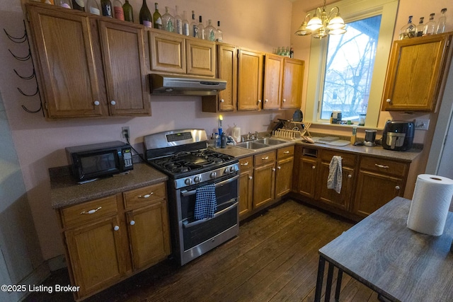 kitchen featuring under cabinet range hood, a sink, black microwave, range with two ovens, and dark wood-style floors