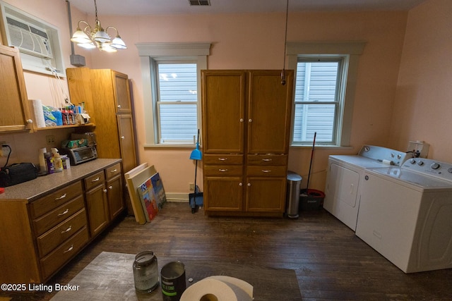 kitchen with a chandelier, brown cabinets, dark wood finished floors, an AC wall unit, and washer and clothes dryer