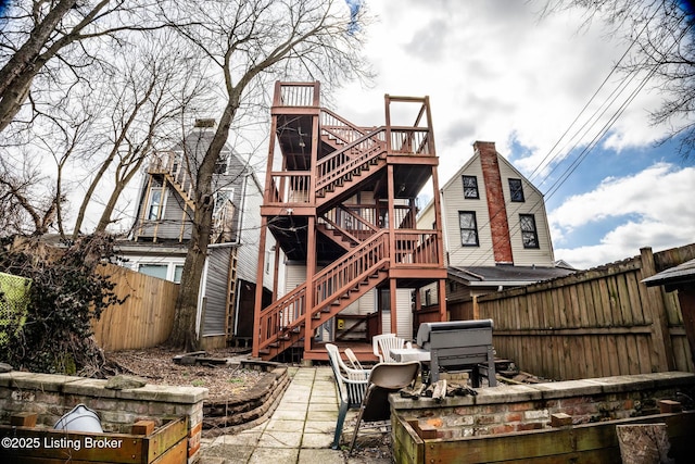 back of house featuring a fenced backyard, stairs, and a patio