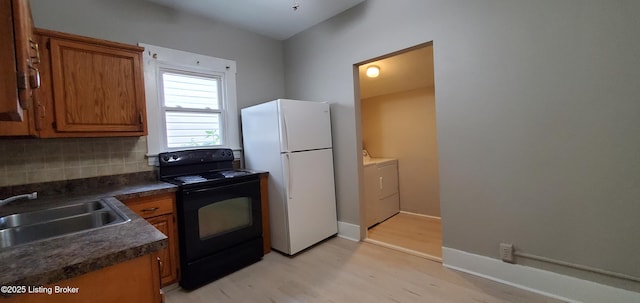 502 Montana Ave, Louisville, KY 40208 - kitchen featuring black electric range oven, brown cabinetry, washer and dryer, and freestanding refrigerator