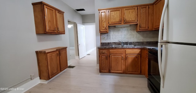 502 Montana Ave, Louisville, KY 40208 - kitchen with a sink, electric range, brown cabinetry, and freestanding refrigerator
