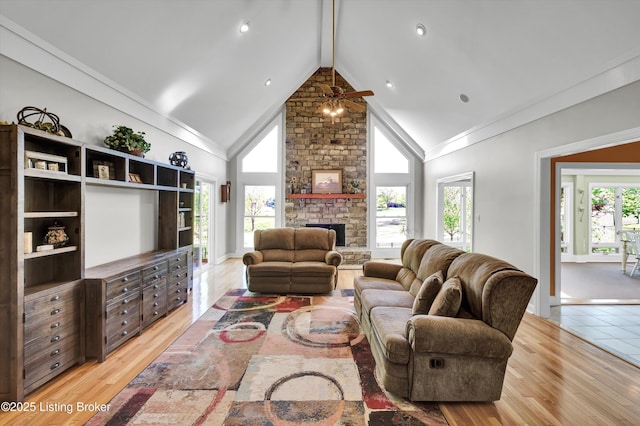 living room with ceiling fan, plenty of natural light, high vaulted ceiling, beam ceiling, and a fireplace