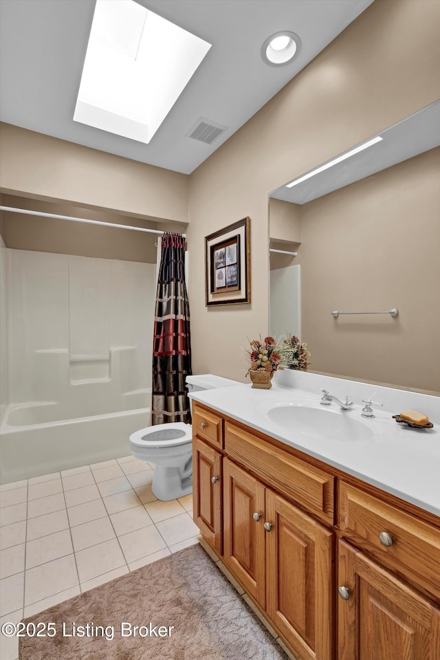 bathroom with a skylight, tile patterned floors, toilet, vanity, and shower / bath combination with curtain